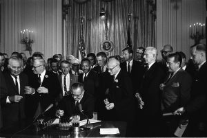 USA: przewodnik - Podpisanie Aktu o Prawach Obywatelskich. Za prezydentem Johnsonem znajduje się Martin Luther King.